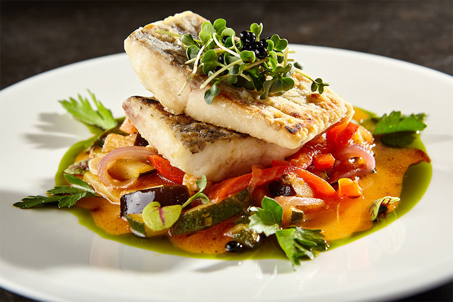 Filete de pescado con verduras preparado por un chef privado en Cabo.
