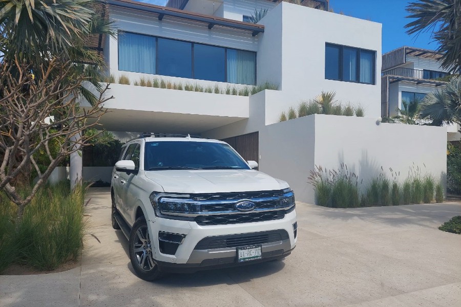 SUV blanco delante de un alquiler vacacional de lujo